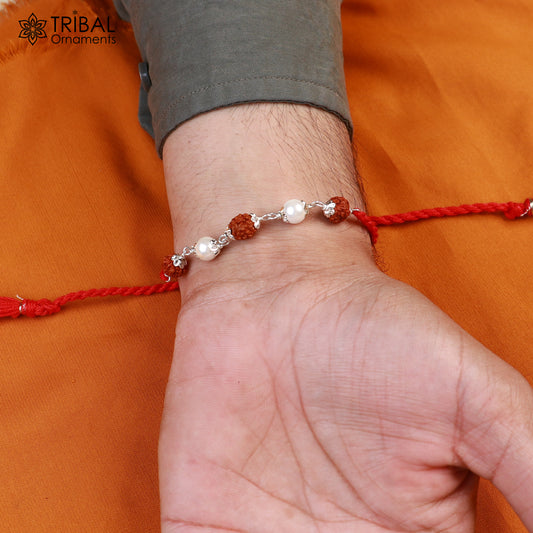 Sterling silver RUDRAKSHA and pearl beads Rakhi bracelet with red thread from TRIBAL ORNAMENTS, featuring intricate design and craftsmanship.