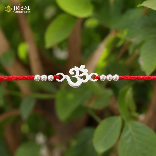 Sterling silver OM design bracelet with red thread Rakhi, featuring intricate details and traditional Indian craftsmanship.