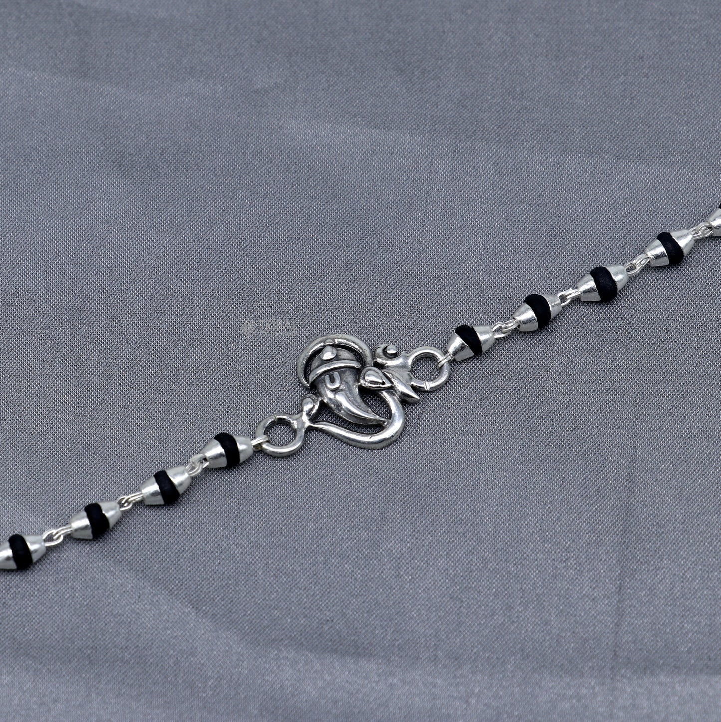 Sterling silver Lord Ganesha bracelet with black Tulsi beads, handmade Hindu prayer beads and rakhi from Tribal Ornaments.