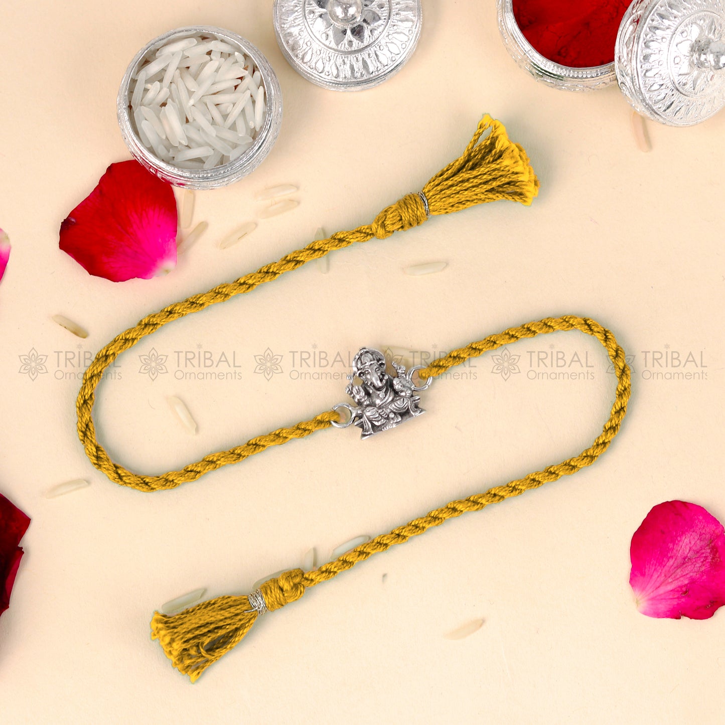 Sterling silver Lord Ganesha design thread rakhi bracelet with red thread from TRIBAL ORNAMENTS, featuring a detailed Ganesha pendant.