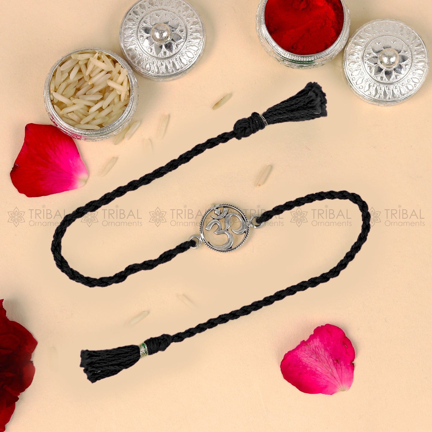 925 sterling silver OM design thread rakhi bracelet with red thread from TRIBAL ORNAMENTS, featuring traditional silver pendant.
