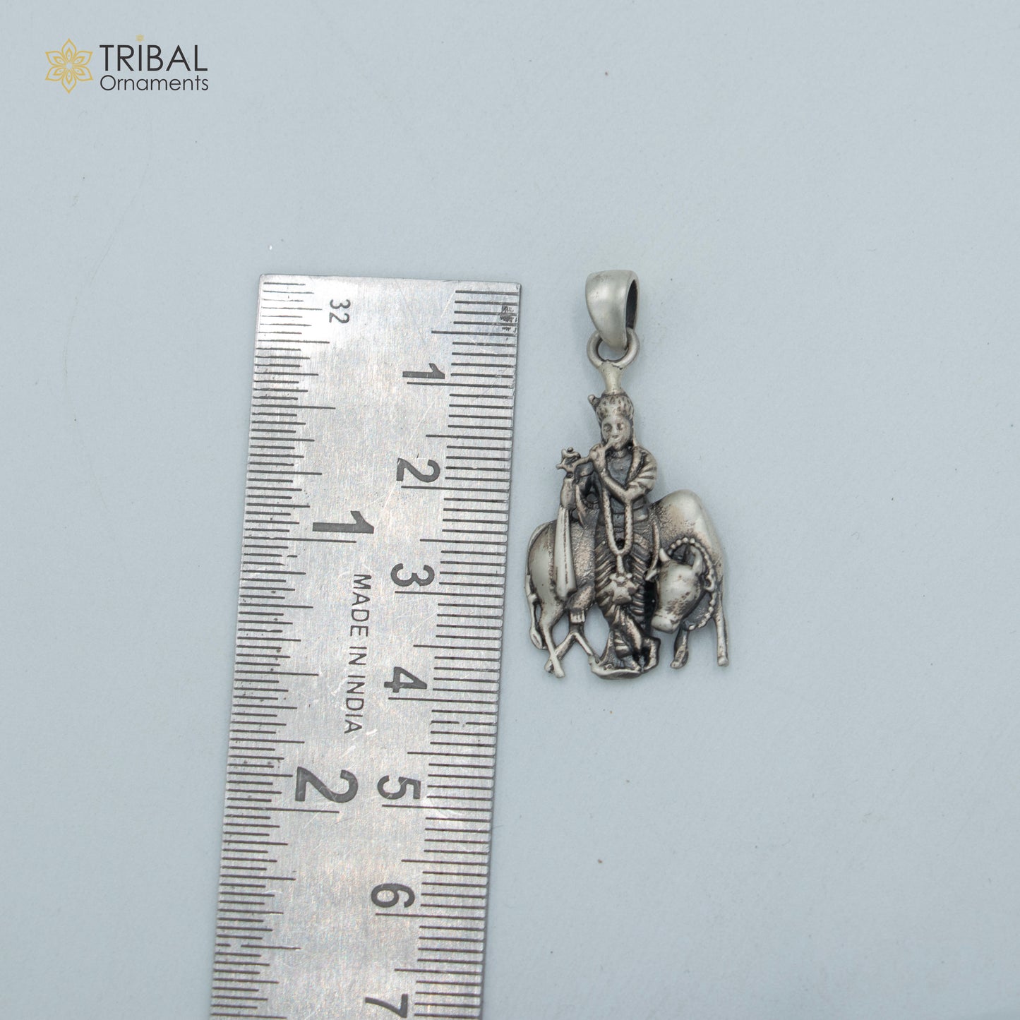 Sterling silver Lord Krishna with cow pendant on chain, tribal jewelry featuring detailed Hindu deity and animal design.