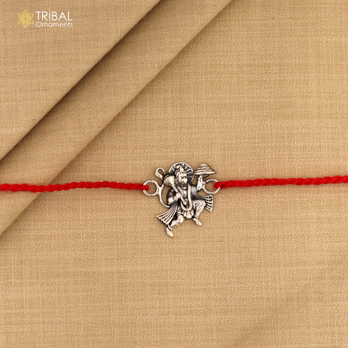 925 sterling silver Flying Hanuman idol Rakhi with red thread from Tribal Ornaments, featuring intricate divine god design.