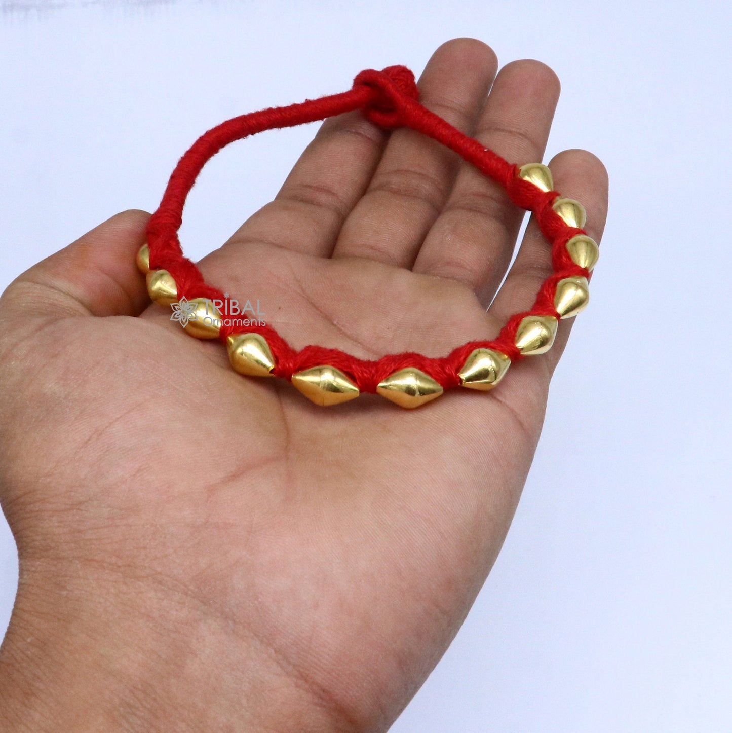 22KT yellow gold handmade dholki beads oval-shaped bracelet or anklet from Tribal Ornaments with custom thread, ethnic tribal jewelry.