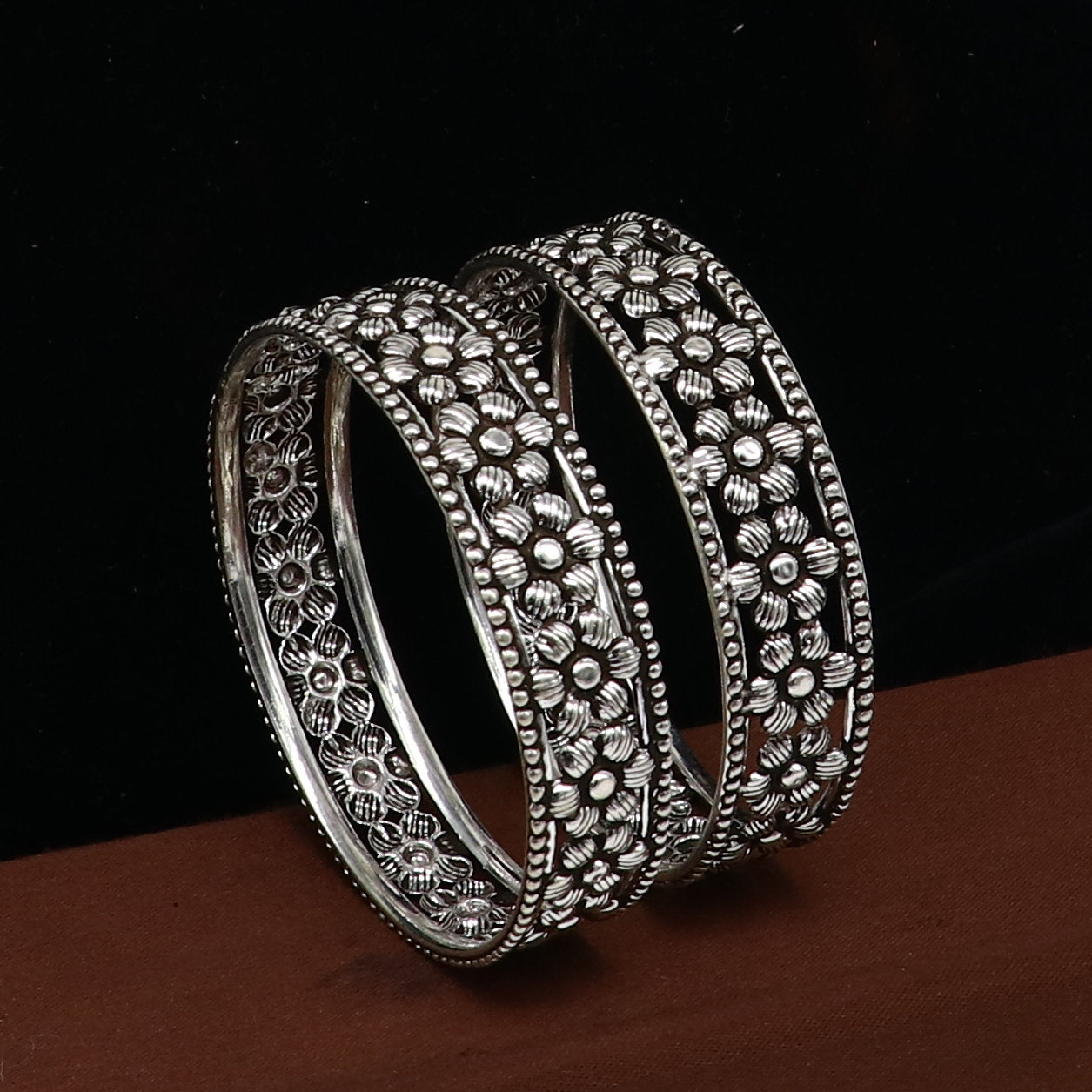 Sterling silver wide floral design bangle bracelet by TRIBAL ORNAMENTS, featuring intricate floral pattern and ethnic style.