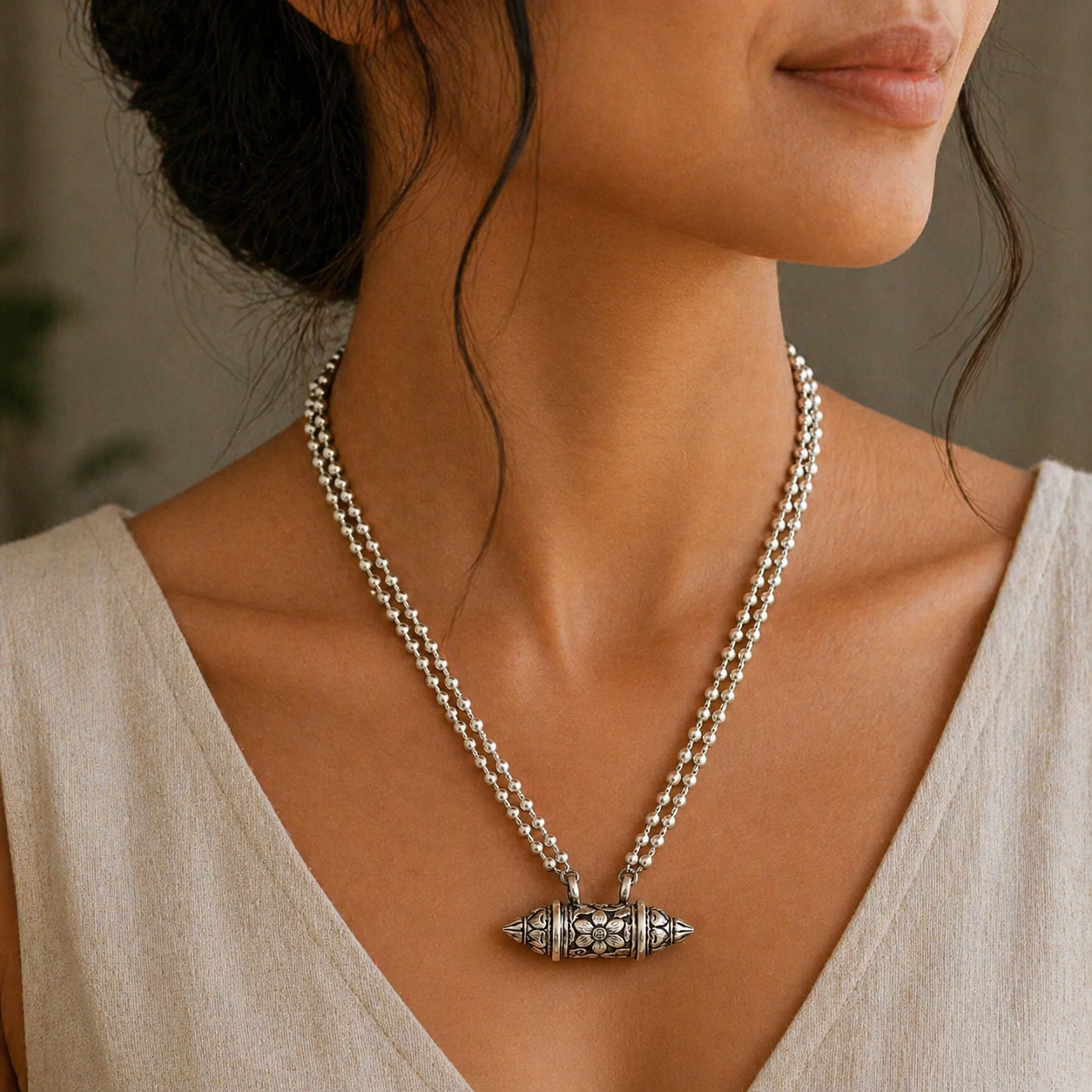 Sterling silver vintage amulet box pendant with ethnic tribal design, paired with a beaded necklace featuring mantra motifs.