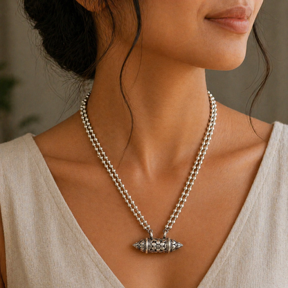 Sterling silver vintage amulet box pendant with ethnic tribal design, paired with a beaded necklace featuring mantra motifs.