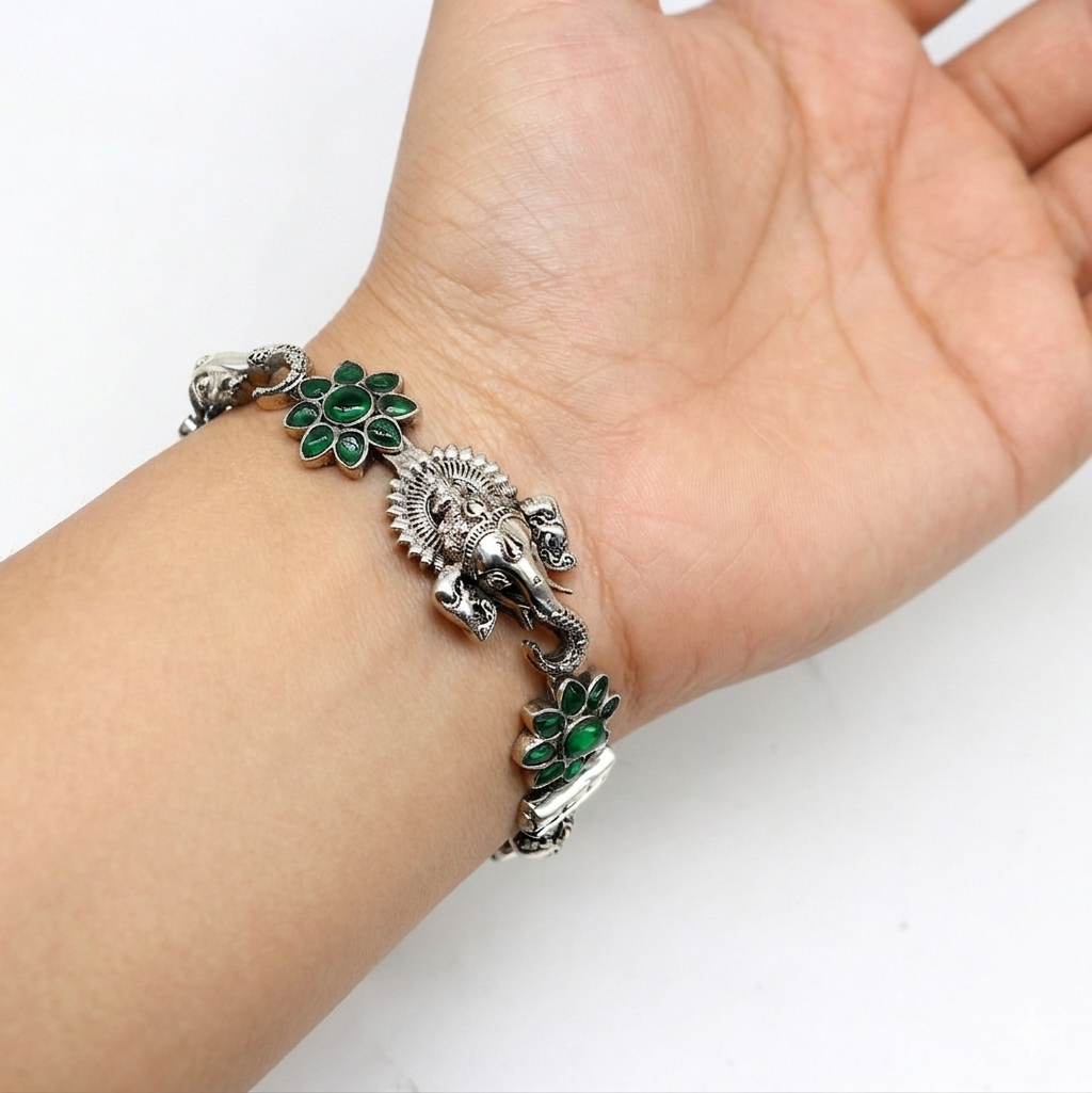 925 sterling silver Ganesha bangle bracelet with floral design and green stone, showcasing ethnic jewelry craftsmanship.