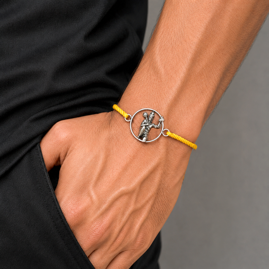 Sterling silver Hanuman idol bracelet with red thread rakhi, featuring intricate design and traditional craftsmanship by TRIBAL ORNAMENTS.