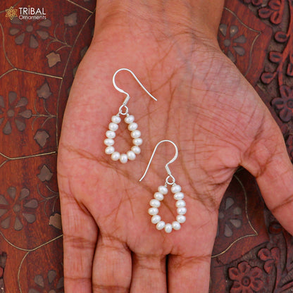 Sterling silver pearl drop dangle earrings by TRIBAL ORNAMENTS with elegant pearl accents and silver hooks.