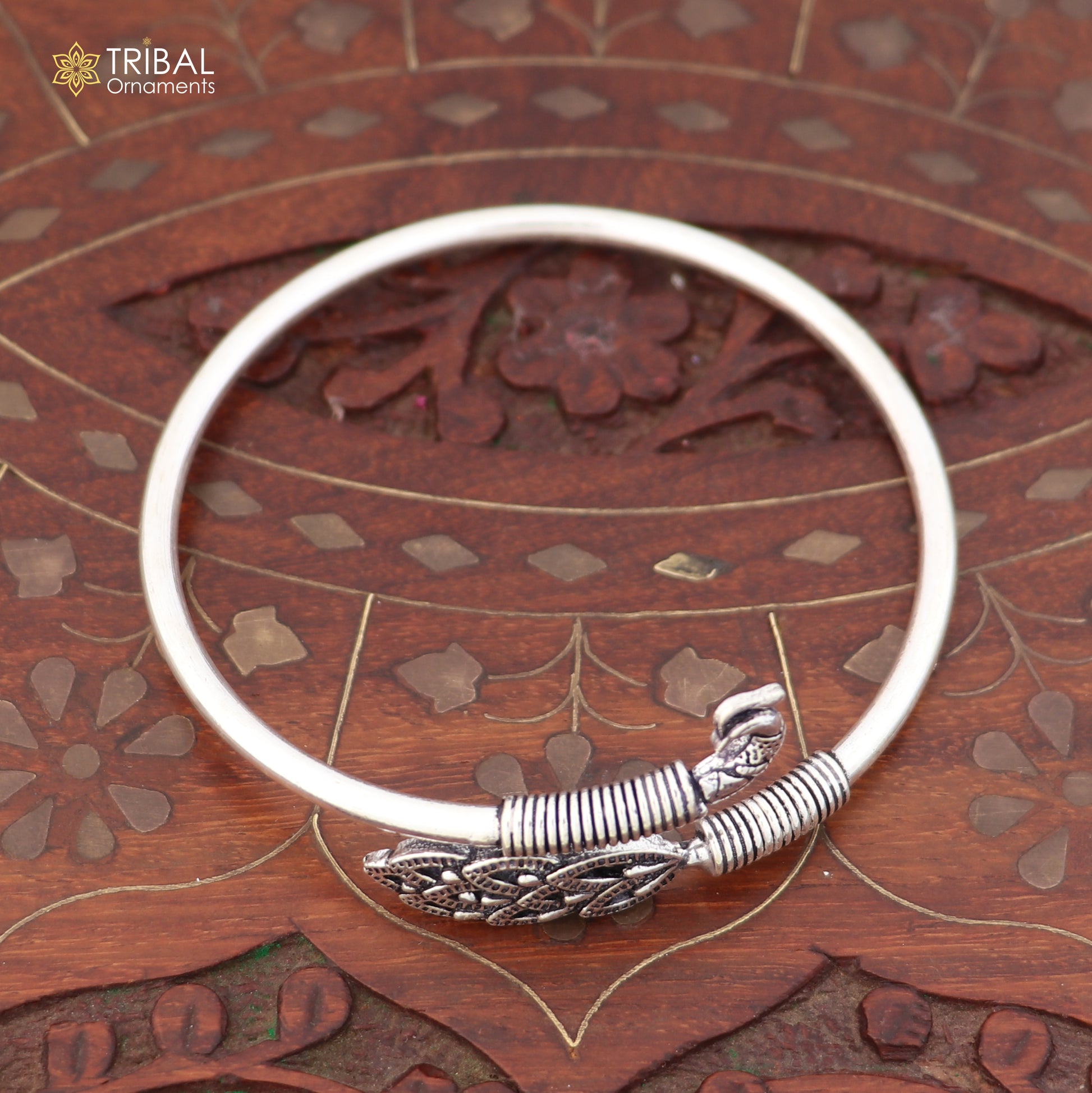 Sterling silver Peacock style bangle bracelet by TRIBAL ORNAMENTS, featuring an easy slip-on design and intricate jewelry details.