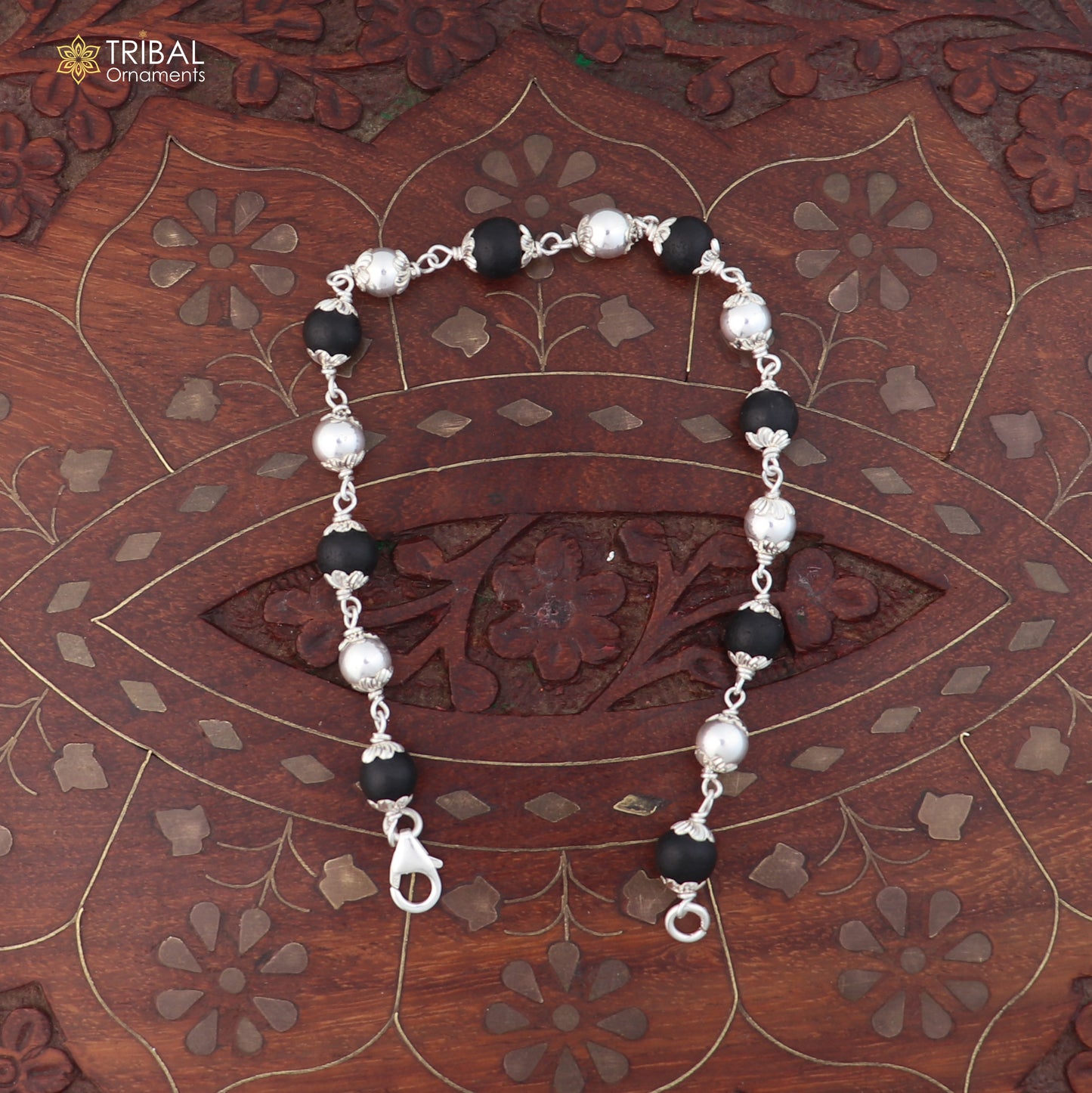 Unisex 925 sterling silver bracelet with black karungali beads from TRIBAL ORNAMENTS, featuring intricate silver details.