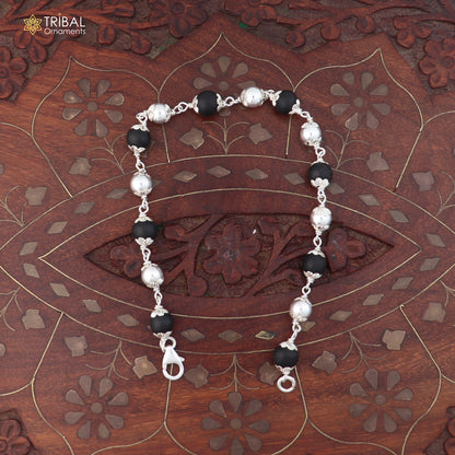 Unisex 925 sterling silver bracelet with black karungali beads from TRIBAL ORNAMENTS, featuring intricate silver details.