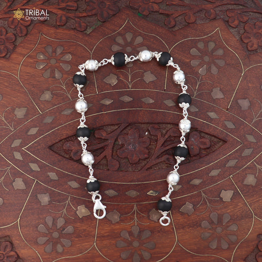 Unisex 925 sterling silver bracelet with black karungali beads from TRIBAL ORNAMENTS, featuring intricate silver details.