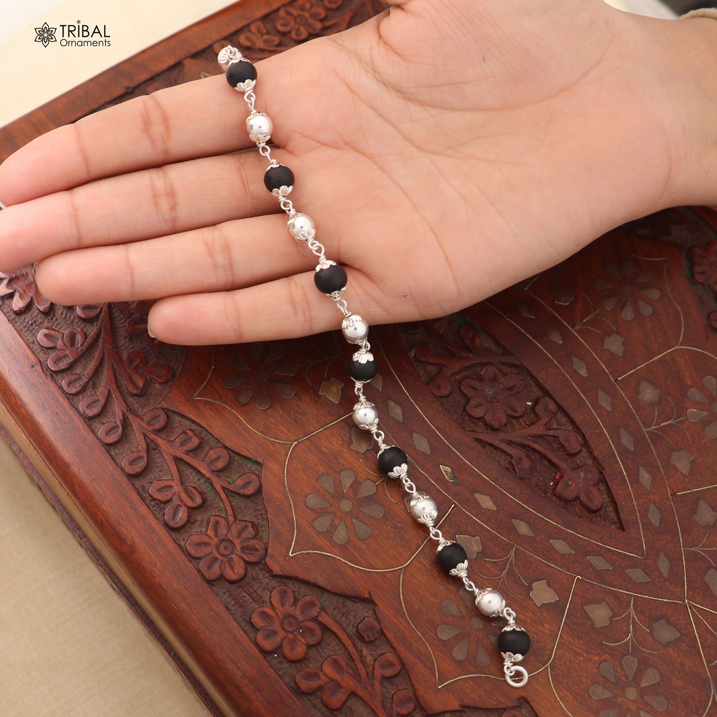 Unisex bracelet with 925 sterling silver and Karungali black beads from TRIBAL ORNAMENTS, featuring intricate bead details.