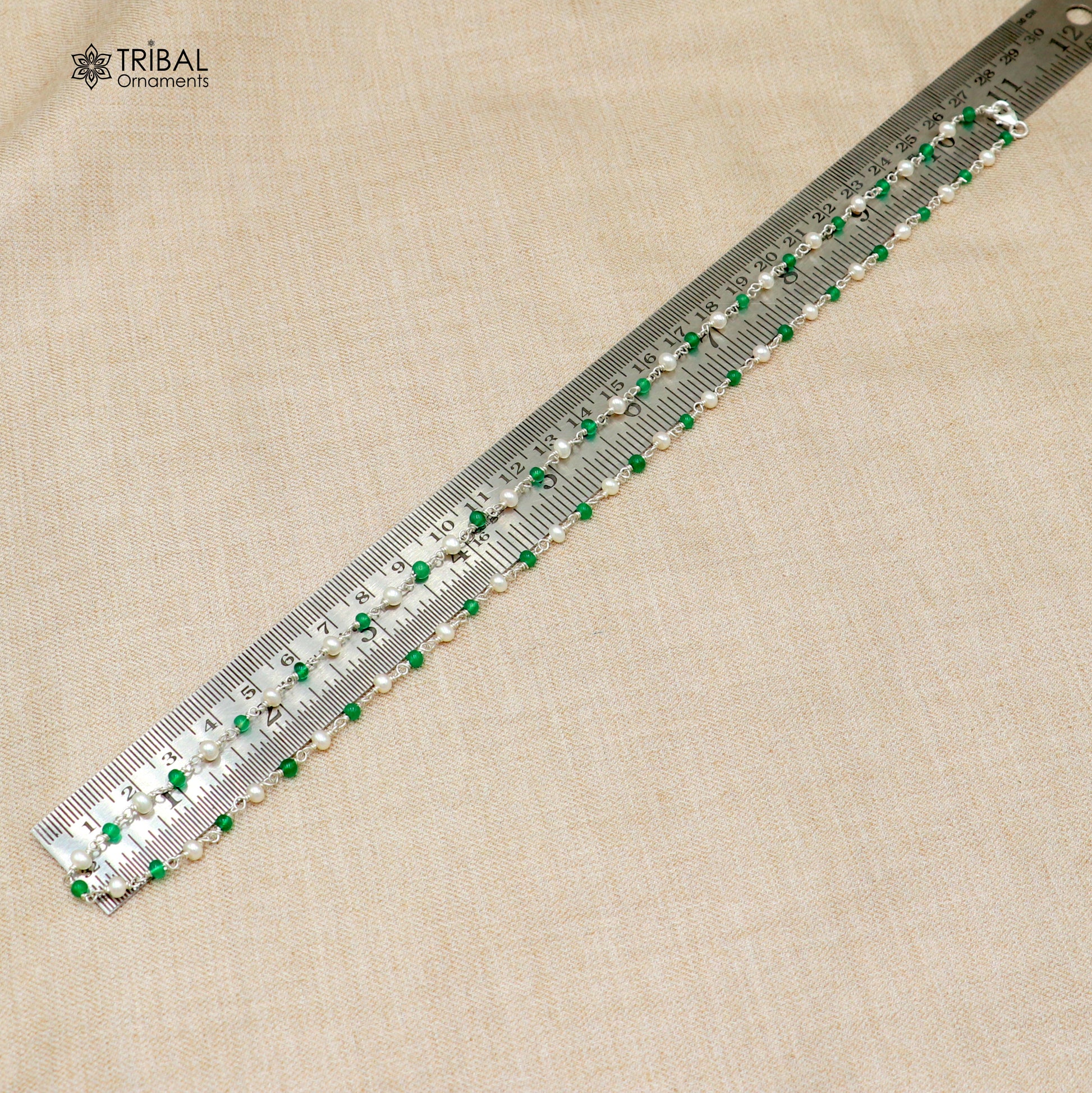 Sterling silver beaded chain with white pearls and green stones, designed by TRIBAL ORNAMENTS, shown in close-up.