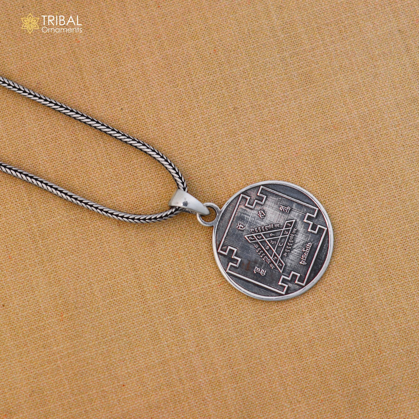Sterling silver Durga Bisa Yantram pendant with chain, tribal jewelry by TRIBAL ORNAMENTS, displayed on a neutral background.