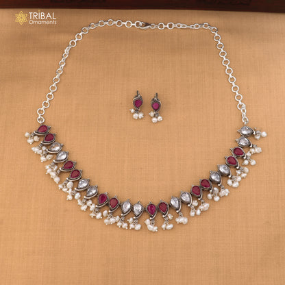 Sterling silver tribal jewelry set with ruby red and white cut stones, includes necklace and matching earrings.