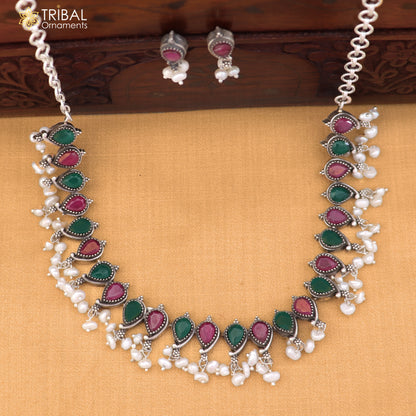 Sterling silver tribal jewelry set with ruby red and white cut stones, includes necklace and earrings with oxidized finish.