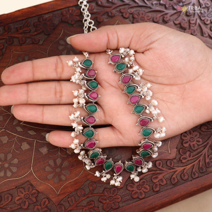 Sterling silver ethnic jewelry set with ruby red and white cut stones, including necklace and earrings with oxidized finish.