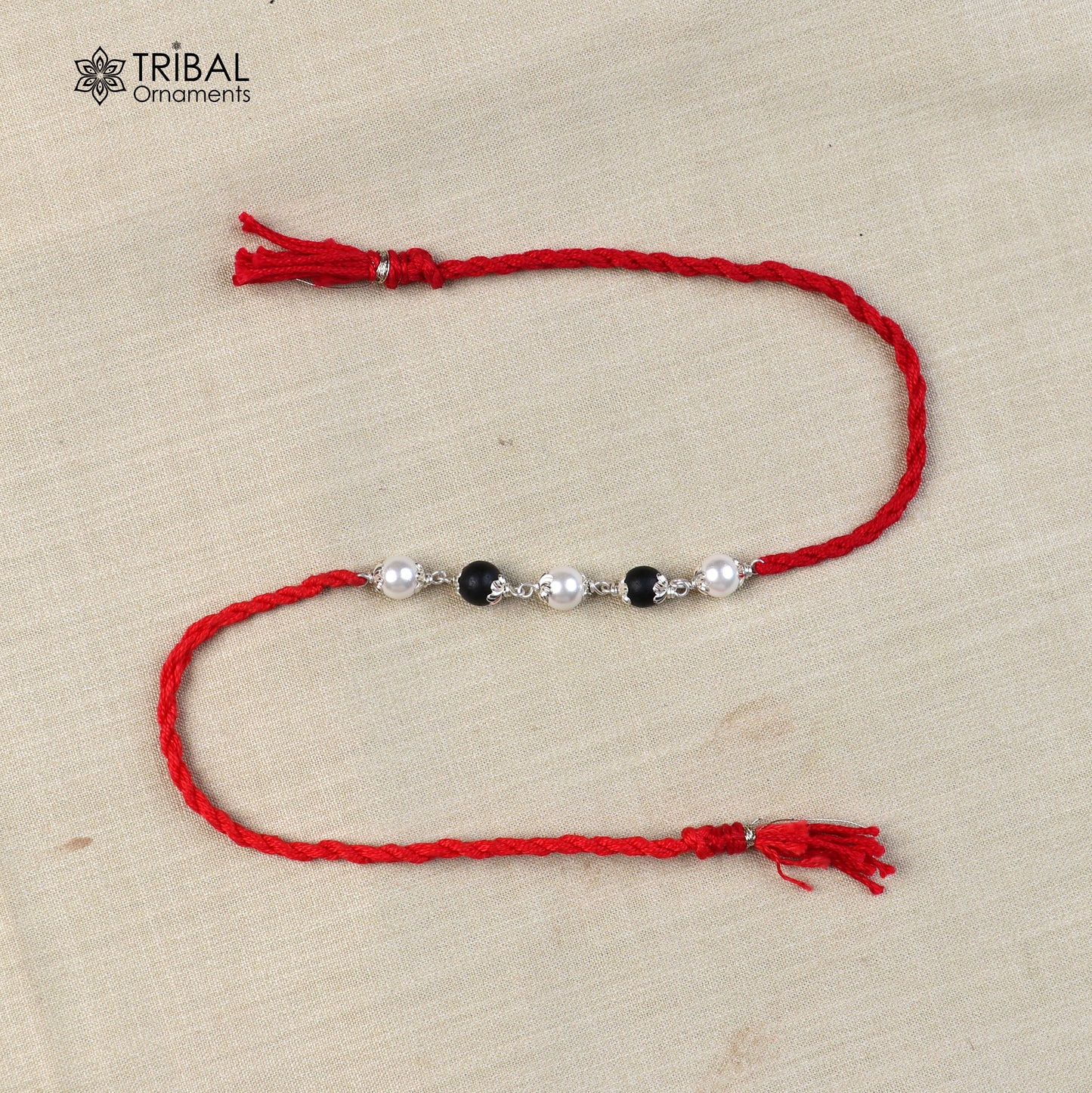 925 sterling silver KARUNGALI and pearl beads Rakhi bracelet with red thread, handcrafted tribal design from Tribal Ornaments.