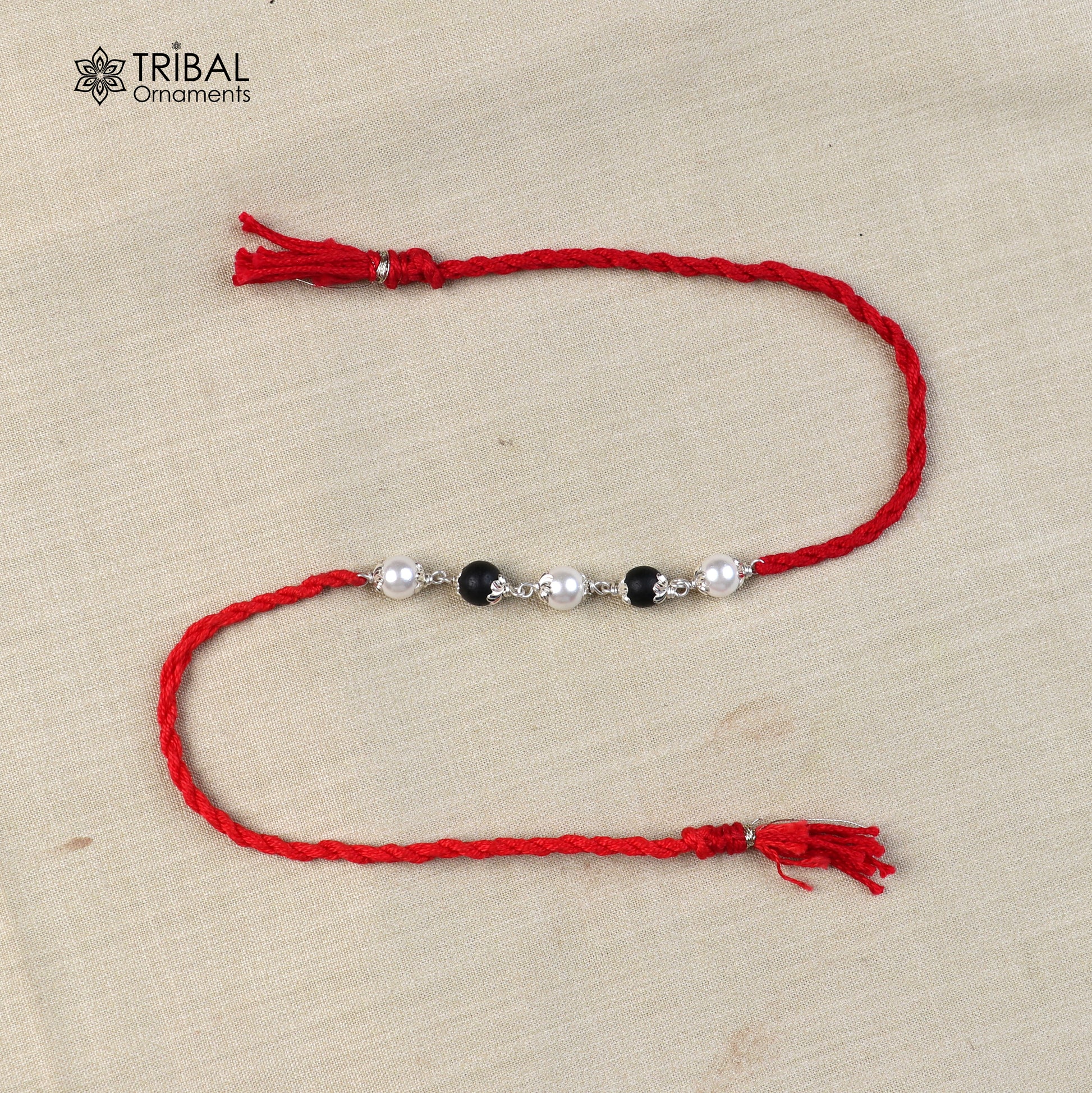 925 sterling silver KARUNGALI and pearl beads Rakhi bracelet with red thread, handcrafted tribal design from Tribal Ornaments.