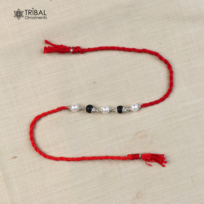 925 sterling silver KARUNGALI and pearl beads Rakhi bracelet with red thread, handcrafted tribal design from Tribal Ornaments.