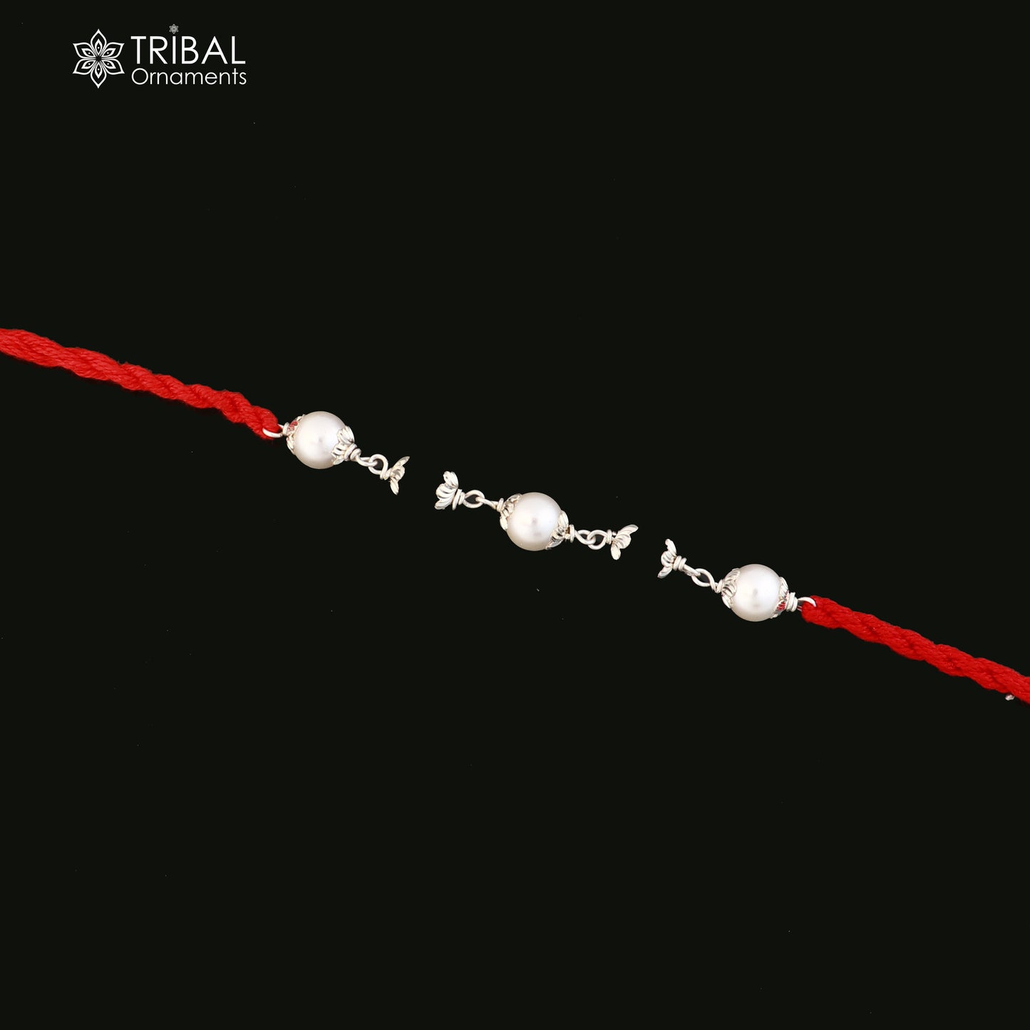 Sterling silver KARUNGALI and pearl beads Rakhi bracelet on red thread, crafted by TRIBAL ORNAMENTS, with intricate design details.