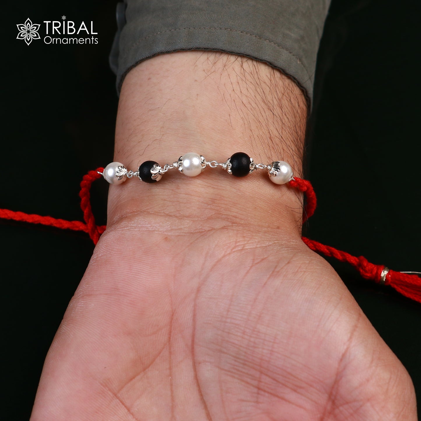 Sterling silver Karungali and pearl beads Rakhi bracelet with red thread, crafted by Tribal Ornaments, for traditional Indian celebrations.