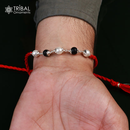 Sterling silver Karungali and pearl beads Rakhi bracelet with red thread, crafted by Tribal Ornaments, for traditional Indian celebrations.