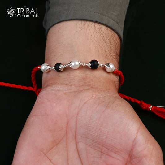 Sterling silver Karungali and pearl beads Rakhi bracelet with red thread, crafted by Tribal Ornaments, for traditional Indian celebrations.