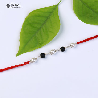 925 sterling silver KARUNGALI and pearl beads Rakhi bracelet with red thread, featuring intricate tribal ornament design.