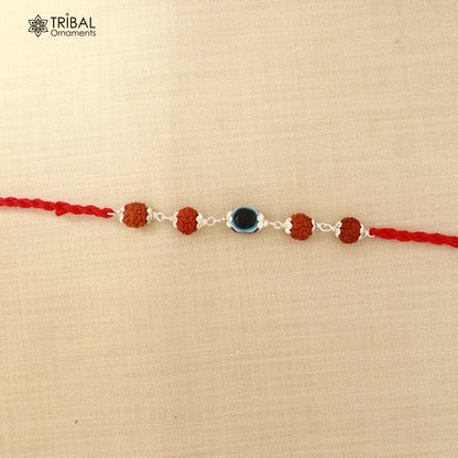 925 sterling silver Rakhi bracelet with Rudraksha and evil eye beads on red thread, from Tribal Ornaments.