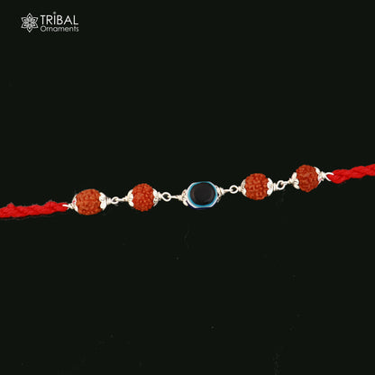 Sterling silver RUDRAKSHA and evil eye beads on red thread rakhi bracelet with tribal ornament design.