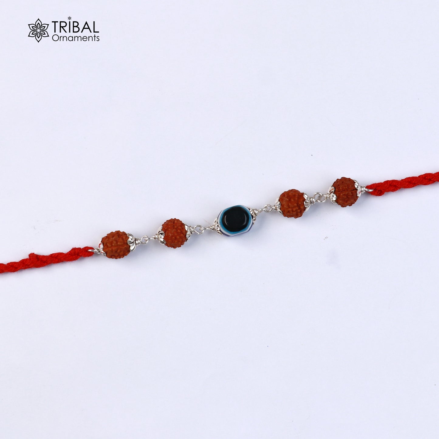Sterling silver RUDRAKSHA and evil eye beads on red thread rakhi bracelet with intricate designs from TRIBAL ORNAMENTS.