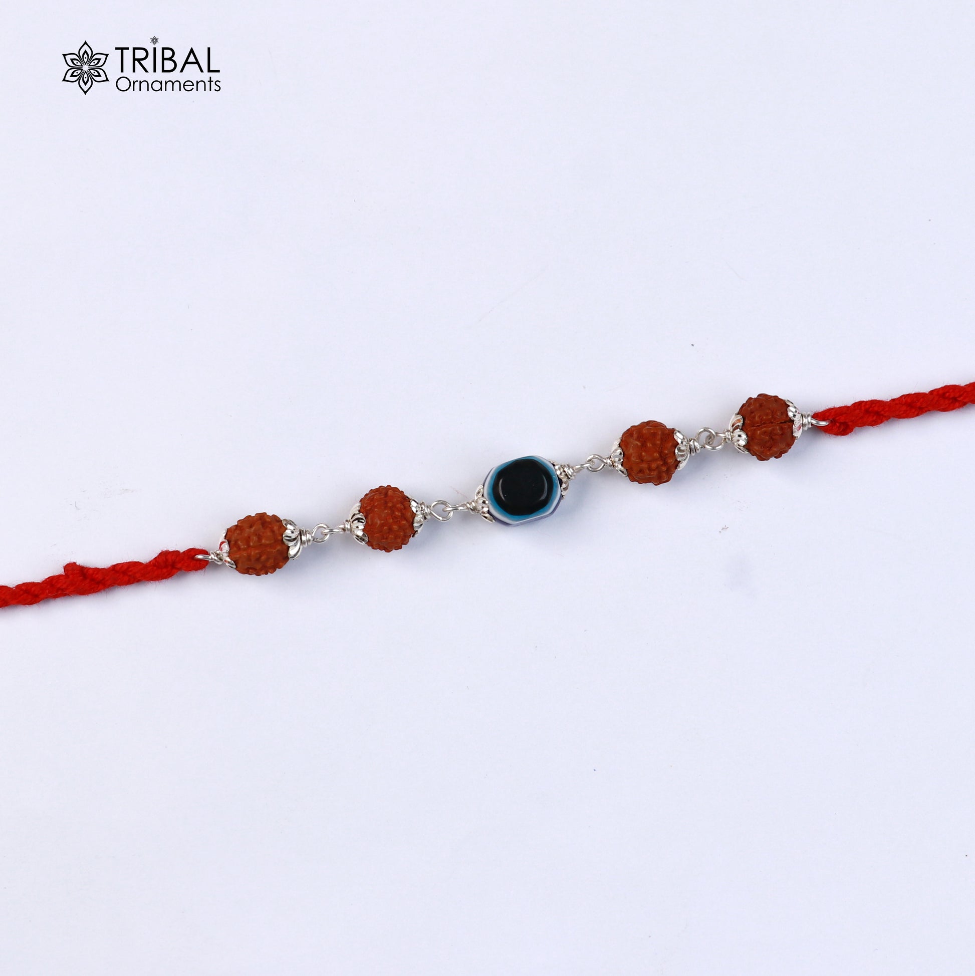 Sterling silver RUDRAKSHA and evil eye beads on red thread rakhi bracelet with intricate designs from TRIBAL ORNAMENTS.
