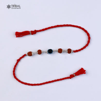 Sterling silver RUDRAKSHA and evil eye beads on red thread rakhi bracelet with intricate tribal design.