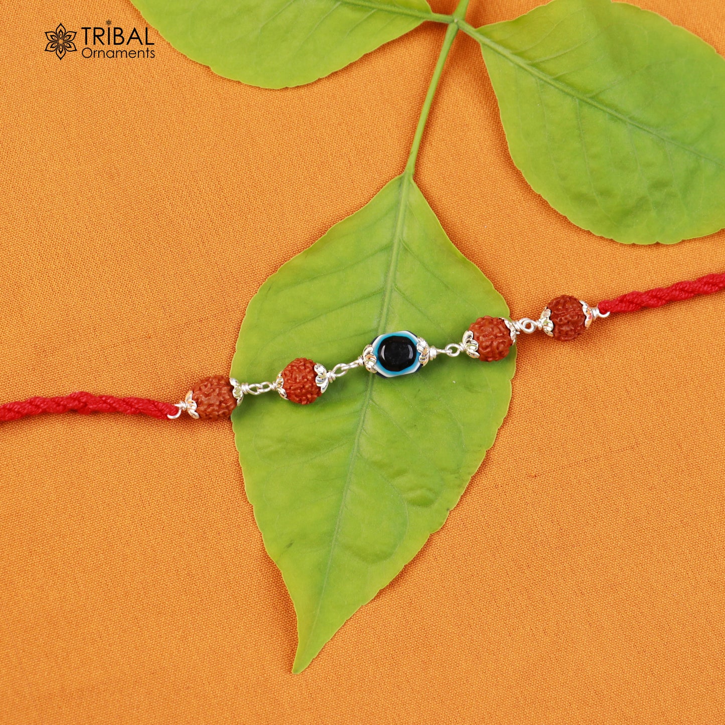 Sterling silver RUDRAKSHA and evil eye beads on red thread Rakhi bracelet with tribal ornament design.
