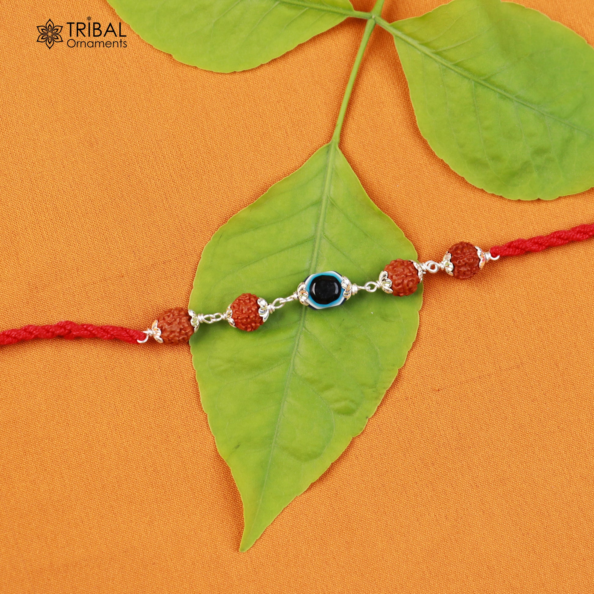 Sterling silver RUDRAKSHA and evil eye beads on red thread Rakhi bracelet with tribal ornament design.