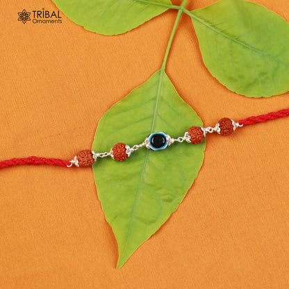 Sterling silver RUDRAKSHA and evil eye beads on red thread Rakhi bracelet with tribal ornament design.