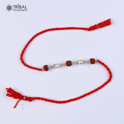 Sterling silver RUDRAKSHA and pearl beads Rakhi bracelet with red thread from TRIBAL ORNAMENTS, featuring intricate design details.