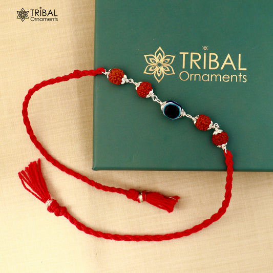 Sterling silver RUDRAKSHA and evil eye beads on red thread rakhi bracelet with intricate design by TRIBAL ORNAMENTS.