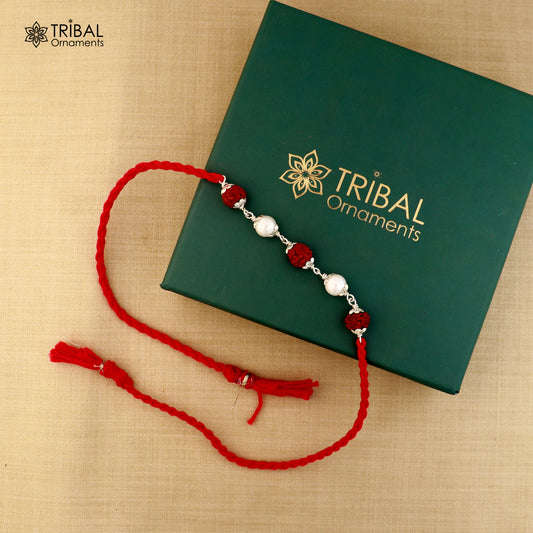 Sterling silver RUDRAKSHA and pearl bead Rakhi bracelet on red thread with intricate design, from Tribal Ornaments.