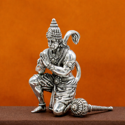 Handmade 2.5-inch 925 silver Lord Hanuman statue sculpture on orange background for puja or gifting, crafted by TRIBAL ORNAMENTS.