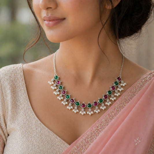 Sterling silver necklace with red and green stones, pearls, and charms, perfect for weddings and special occasions.