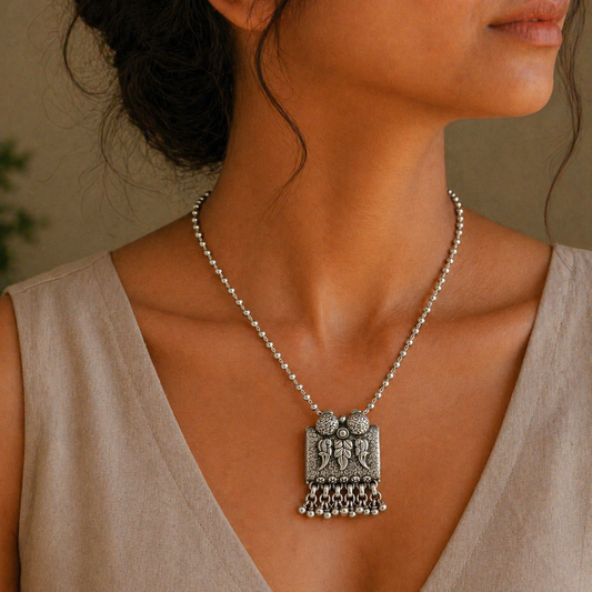 Sterling silver bird pendant with intricate tribal design, paired with a beaded necklace, from TRIBAL ORNAMENTS.