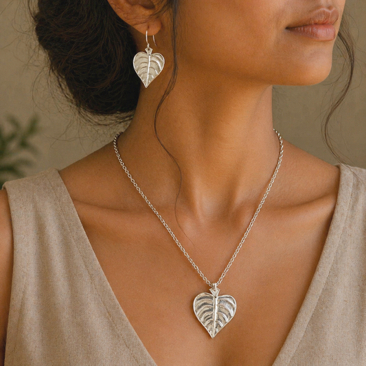 Sterling silver heart-shaped pendant with peepal tree leaf design and matching hoop earrings, tribal-inspired brides jewelry set.