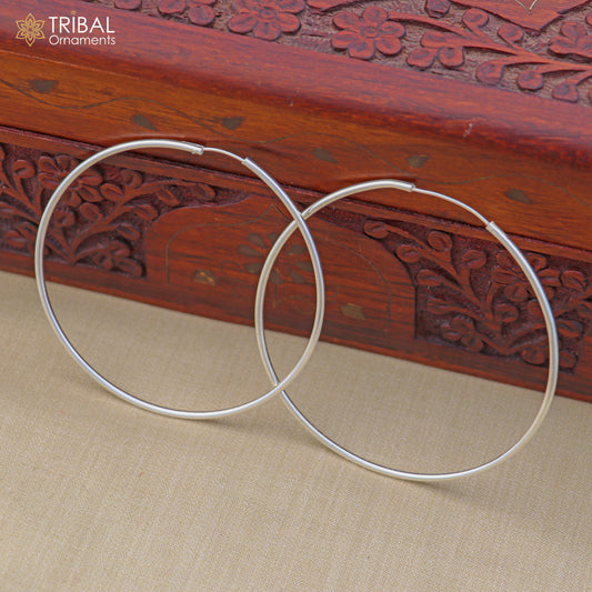 Sterling silver round hoop earrings by TRIBAL ORNAMENTS, showcasing elegant, polished jewelry design in close-up image.