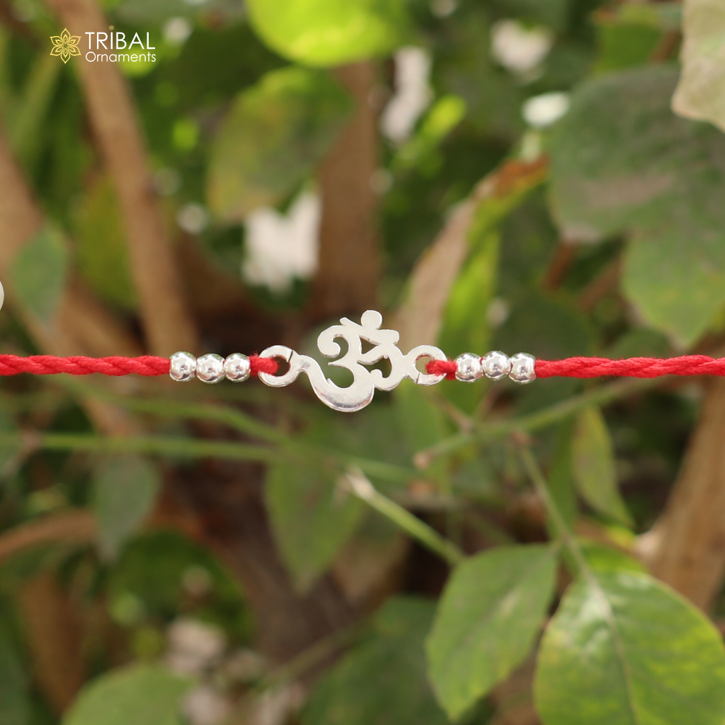 Sterling silver OM AUM symbol bracelet with red thread, tribal design, handcrafted rakhí by Tribal Ornaments.