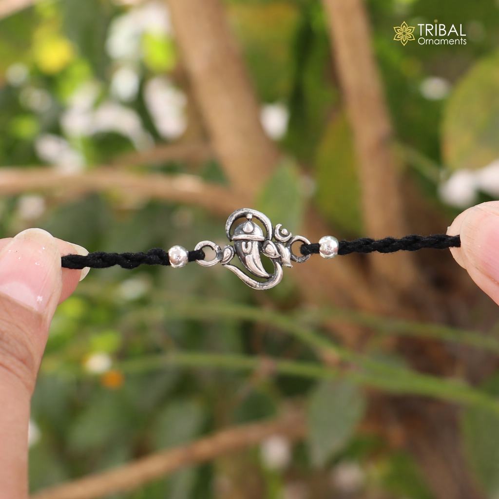 Sterling silver Lord Ganesha "Aum" OM design thread rakhi bracelet with intricate details, ideal for religious celebrations.